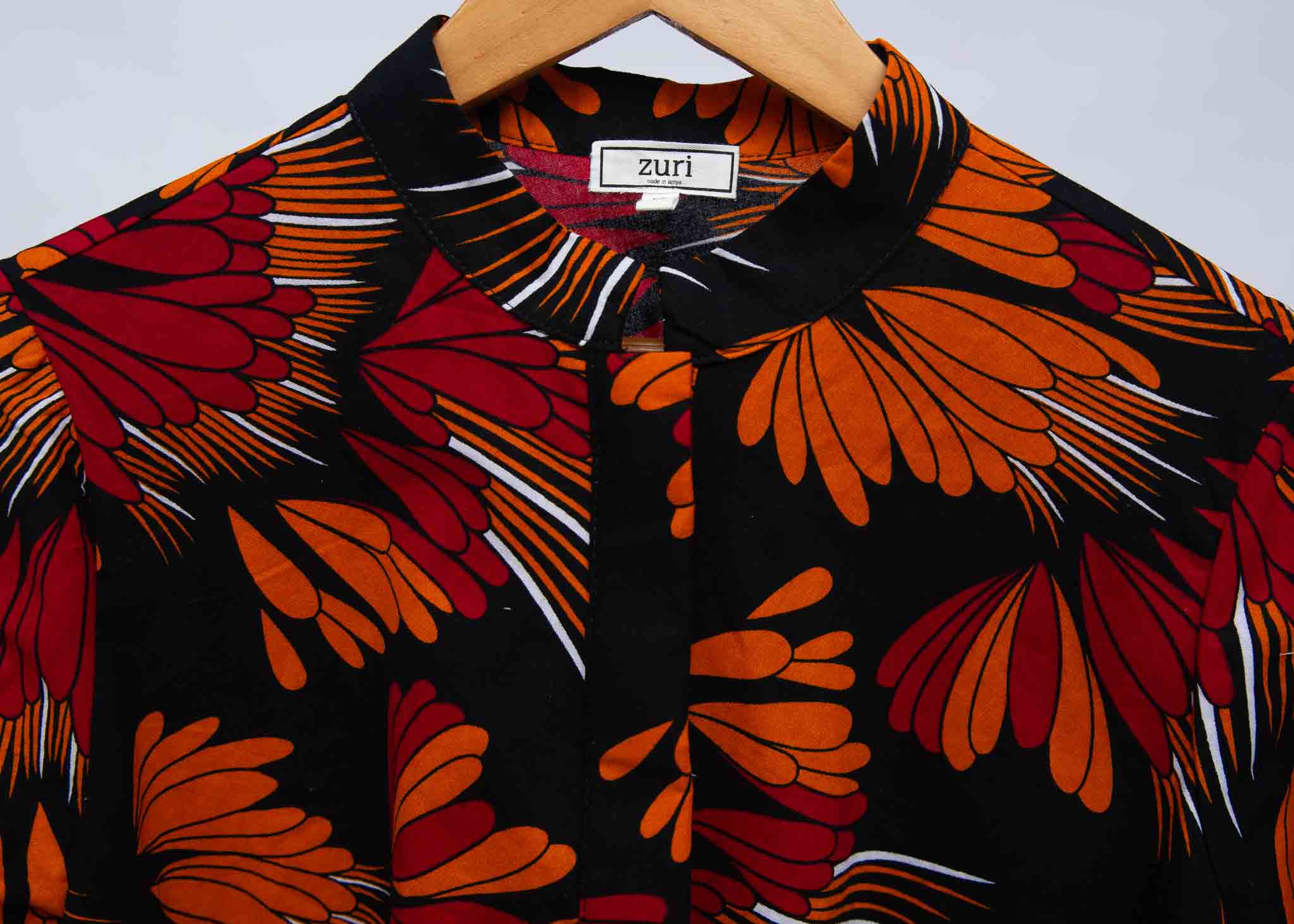 detail of an orange, red and black floral shirt dress