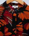 detail of an orange, red and black floral shirt dress