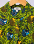 Display of green sleeveless dress with blue and yellow bubble design.