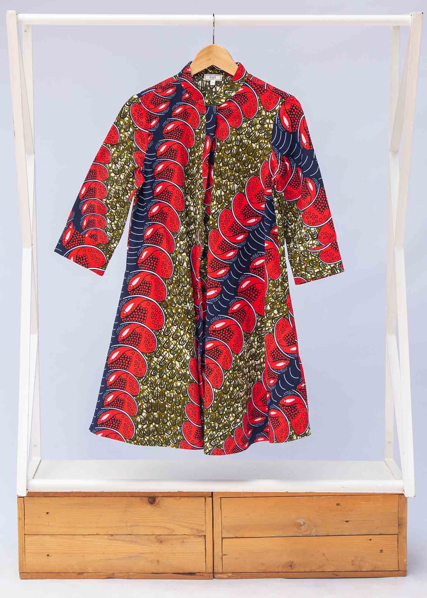 Display of green dress, with bold red and navy fish print.