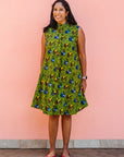 Model wearing green sleeveless dress with blue and yellow bubble design.