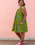 Model wearing green sleeveless dress with blue and yellow bubble design.
