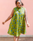 Model wearing green sleeveless dress with blue and yellow bubble design.