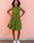 Model wearing green sleeveless dress with blue and yellow bubble design.