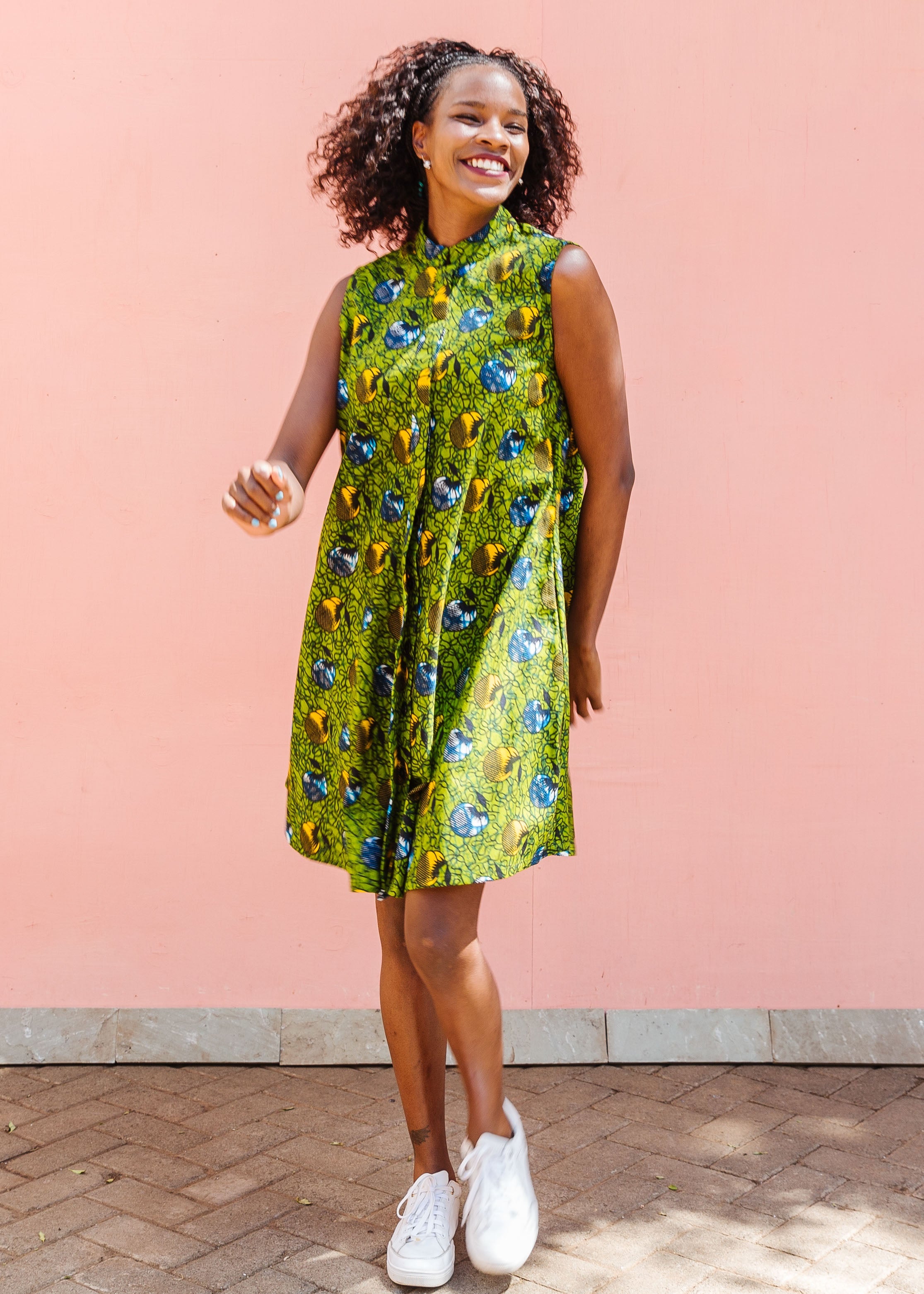 Model wearing green sleeveless dress with blue and yellow bubble design.