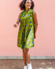 Model wearing green sleeveless dress with blue and yellow bubble design.