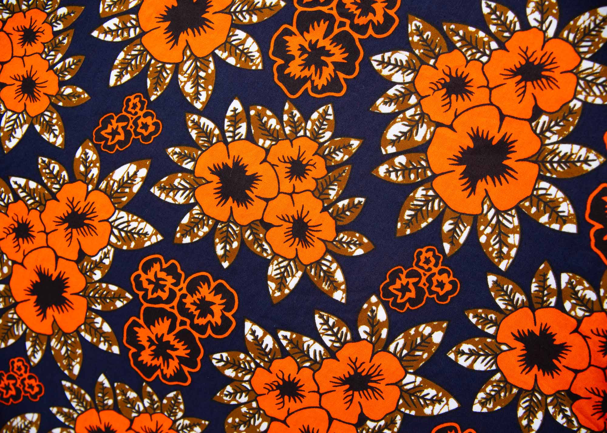 Close up display of navy dress with orange, brown, black and white floral print, fabric