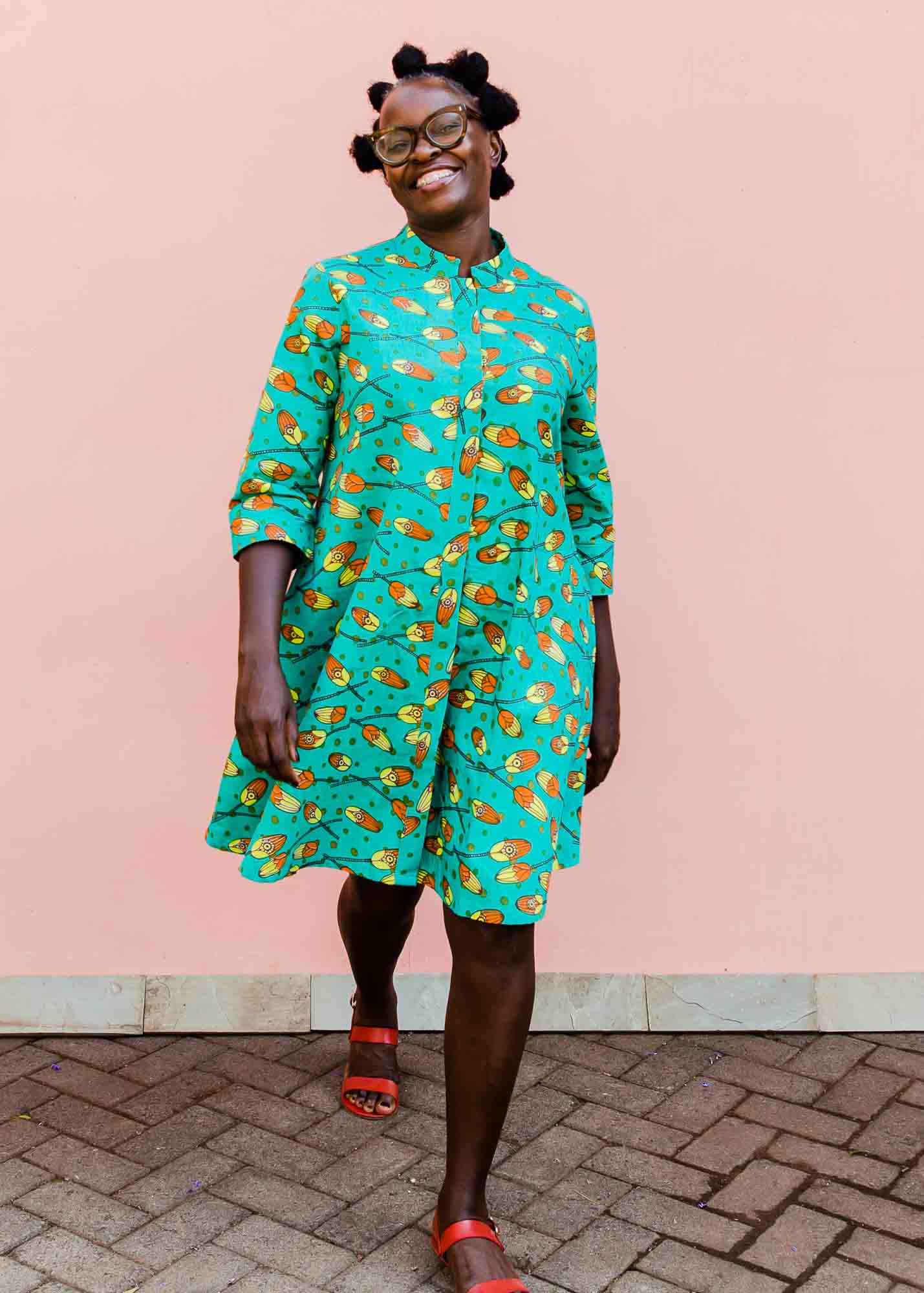 model wearing a teal, orange and yellow pod design dress