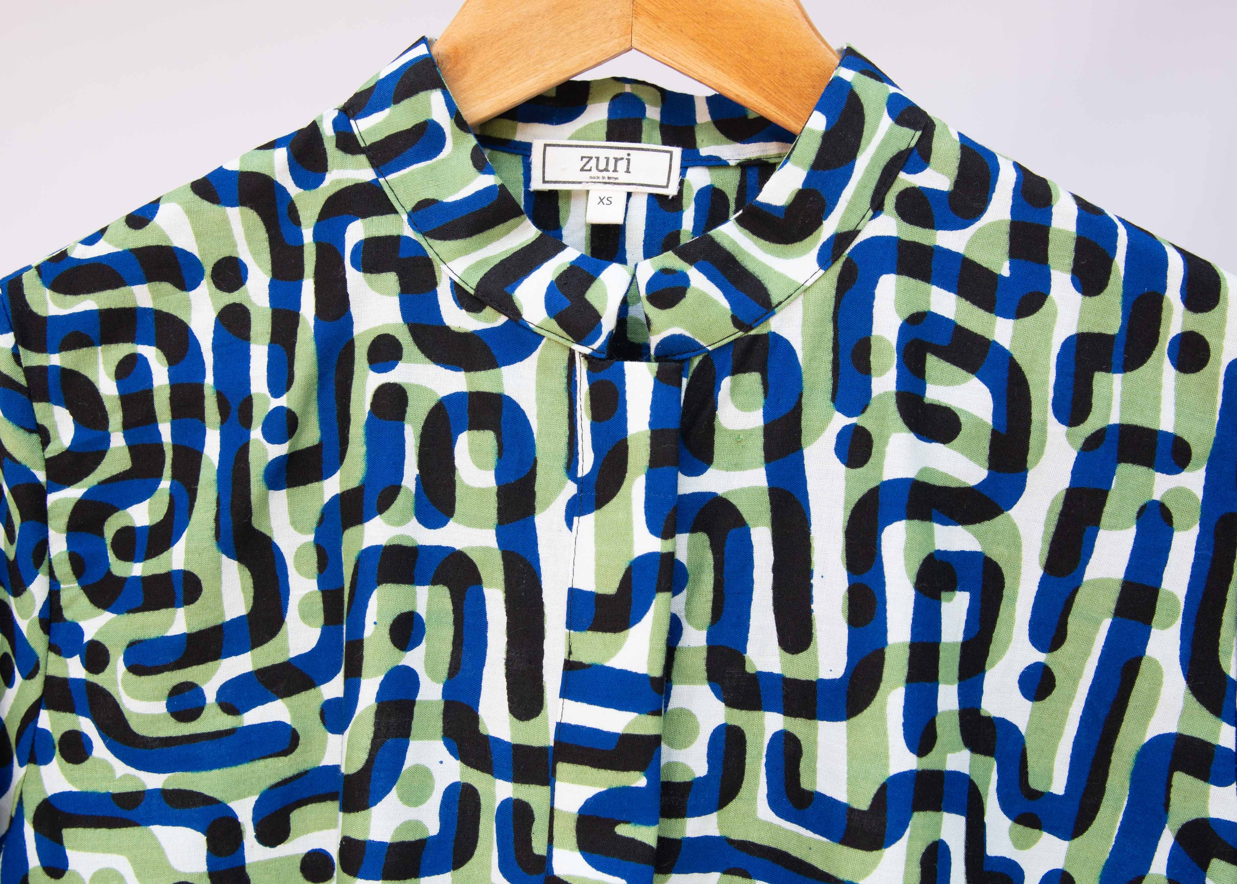 Close up of green, blue, black squiggle print, long sleeved blouse.