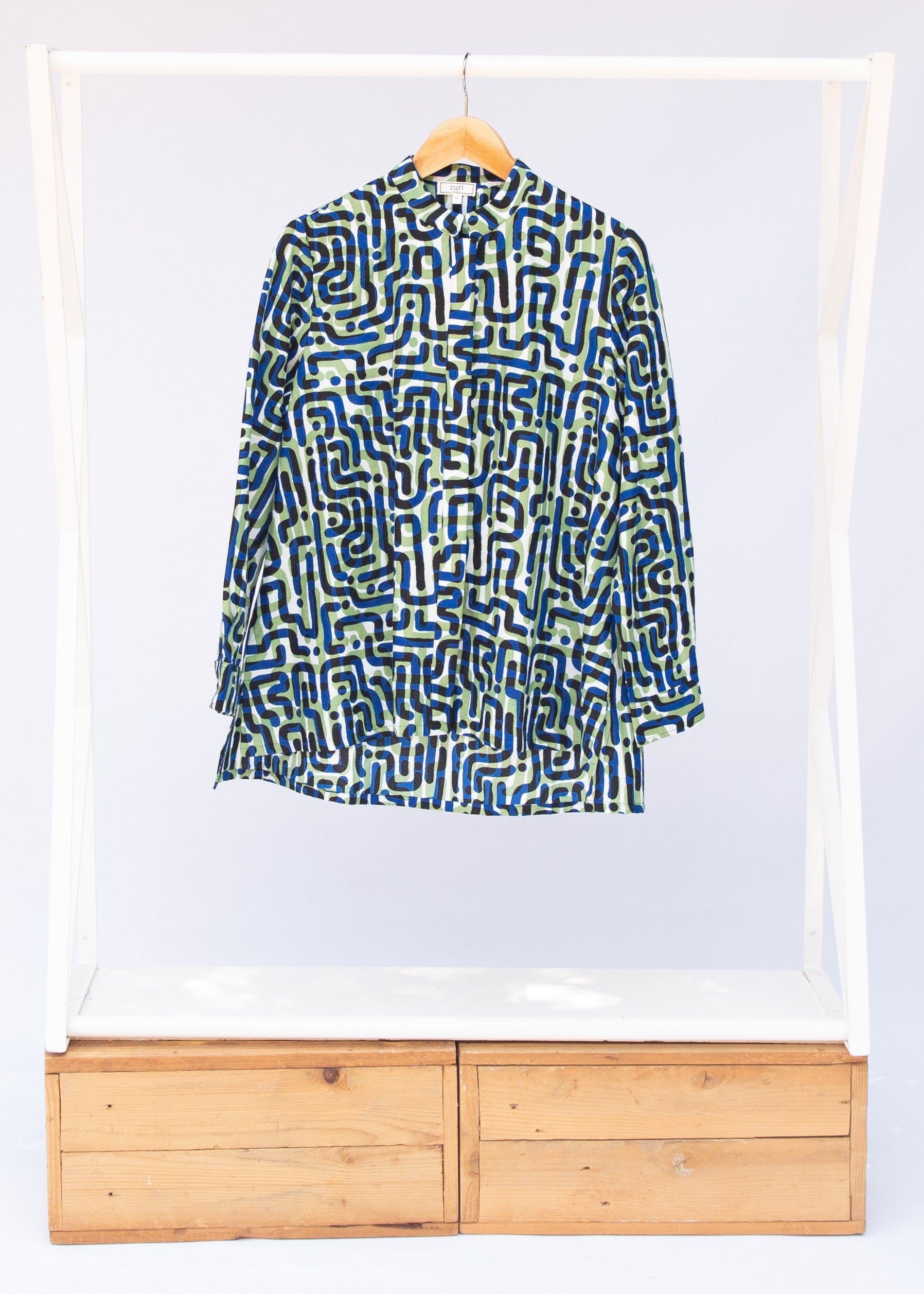 Display of green, blue, black squiggle print, long sleeved blouse.