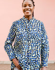 Model wearing green, blue, black squiggle print, long sleeved blouse.